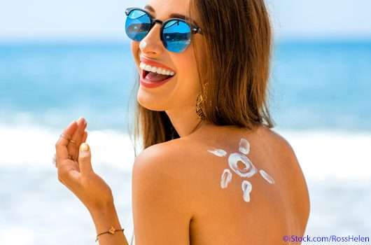 Frau mit Sonnenschutzmittel
